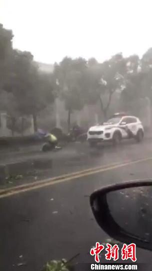 南京一男子大雨天摔倒街頭民警頂風雨為其擋住來往車輛