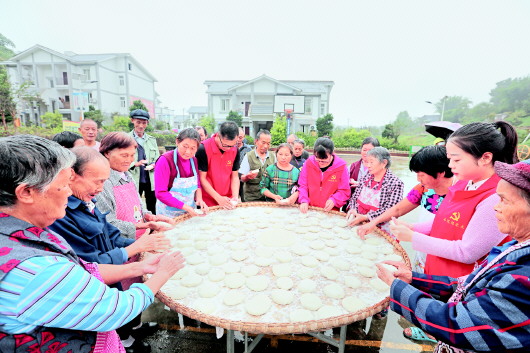 9月16日,在赤水市長沙鎮篤睦村易地扶貧安置點,當地干部群眾歡聚一堂打糍粑,迎中秋。(王長育 攝)