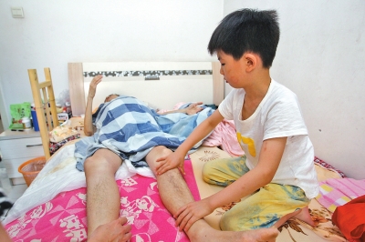 鄭州一教師患癌臥床 7歲兒子幫爸爸按摩胳膊和雙腿