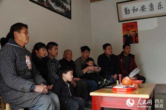 村民胡宗鵬一家人圍坐在客廳看電視。(張櫪 攝)