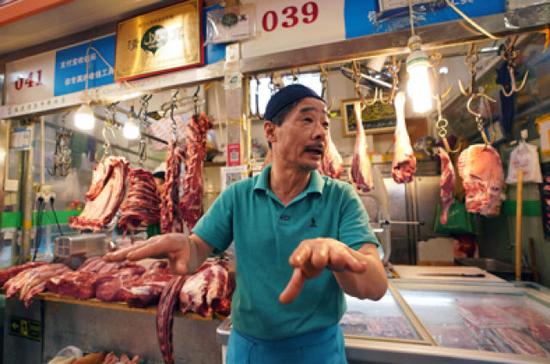 5月8日,在三源里市場內的春蘭清真牛羊肉店,店主劉忠玉在介紹自己在三源里菜市場的開店經歷。
