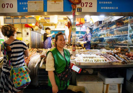 5月8日,在三源里市場,店主干丹君站在072號商鋪前。
